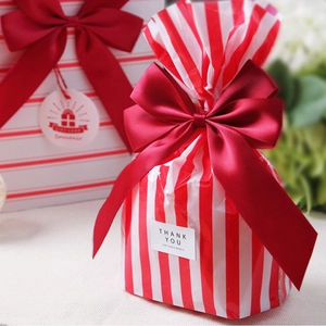 Rot-weiß gestreifte Geschenktüte mit roter Satinschleife und Dankeschön-Aufkleber