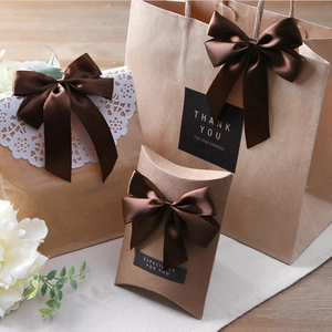 Braune Satin-Schleife auf Kraft-Geschenktüten und Kissenbox für edle Verpackung