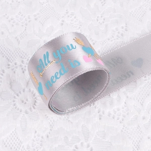 Silver satin ribbon with heart patterns and All You Need Is text for gift wrapping