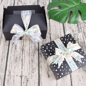 Detail of luxury gift boxes with decorative Love printed satin ribbons on wood