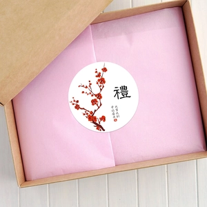 Détail d'un sceau adhésif festif rond avec fleur rouge et vœux de bonheur sur le coffret