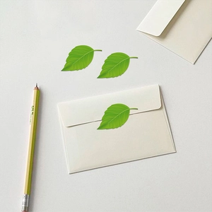 Vue macro d'autocollants en forme de feuille verte avec détails de nervures sur une enveloppe