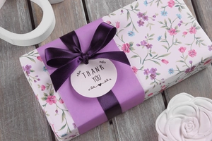 Detail von dunkelviolettem Polyesterband, gebunden auf einer floralen Geschenkbox