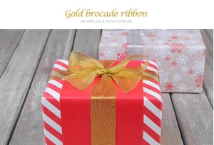 Primer plano de cinta dorada metálica con un lazo sobre una caja de regalo festiva