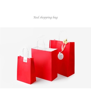 Three red paper gift bags in different sizes with white handles and Thank You tags