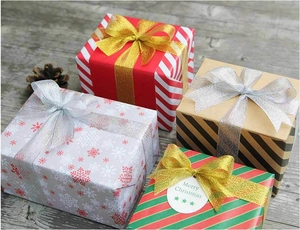 Detalle de cajas de regalo navideñas con cintas brillantes y etiqueta de Merry Christmas