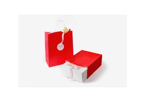 Detail of red gift paper bag with white cotton handle and Thank You label decoration