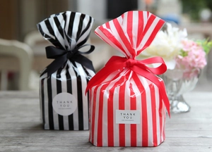 Detail of striped gift bags with ribbon bows and Thank You stickers for gift packaging