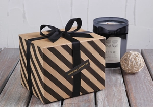 Detail of a gift box with a black grosgrain ribbon bow and elegant gold printed label