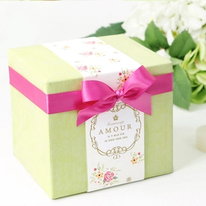 Green striped gift box with rose red satin ribbon bow and romantic floral band