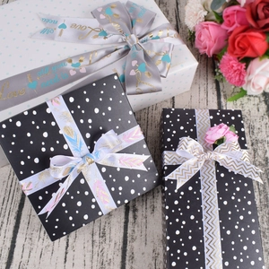 Premium gift box set with elegant satin ribbons and floral accents on wooden background