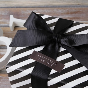 Black grosgrain ribbon bow on striped gift box with 'Especially For You' tag
