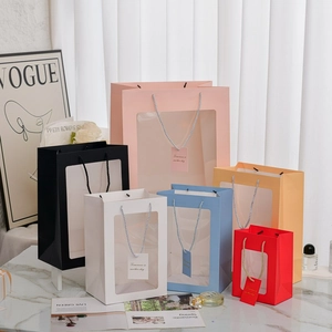Vertical gift bags with transparent window and woven handles in multiple pastel colors