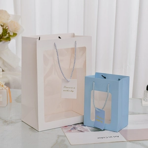 Dettaglio di sacchetti regalo di qualità con finestra trasparente e targhette decorative