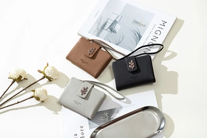 Flat lay of minimalist short wallets with leaf charms and wristlets in neutral tones