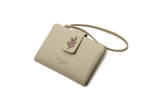 Detail of light green PU leather wallet with leaf charm and wrist strap detail