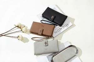 Three leather clutch wallets in black, brown and grey with leaf buckle and wrist strap