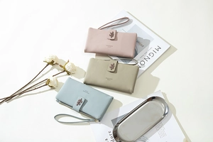 Detailed view of long leather clutches in pink, green, and blue with metal leaf buckles