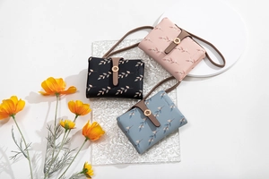 Vue détaillée des fermoirs en métal fleuri et imprimés feuilles sur trois mini sacs