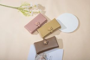 Close-up of long PU leather wallets with floral clasps in pink, yellow and brown