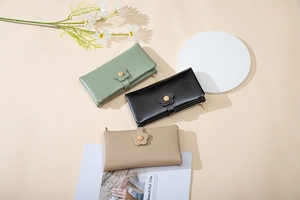 Detailed view of long PU leather wallets in green, black and apricot with camellia buckles