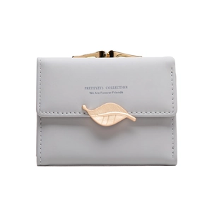 Detail view of small grey wallet with gold leaf buckle and kiss-lock closure
