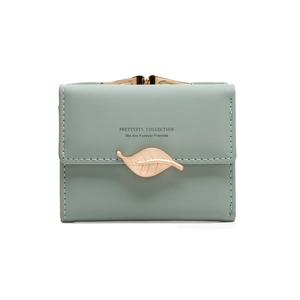 Detail of mint green wallet featuring a golden leaf clasp and secure snap closure