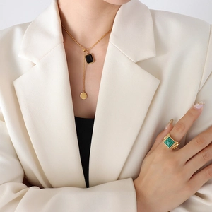Collier lariat doré de design français avec pendentif cristal et bague pierre verte