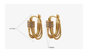 Macro detail of gold U-shaped tassel earrings with pavé cubic zirconia and snake chains