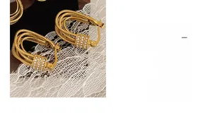 Detailed close-up of gold-plated multi-layer hoop earrings with shimmering pavé zircon stones