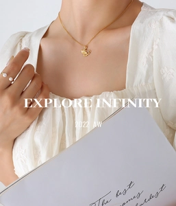 Macro detail of golden ginkgo leaf pendant necklace and double pearl open ring set