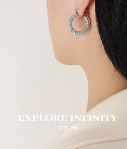 Detailed view of silver U-shaped earrings with micro-pave white zircon worn by a model