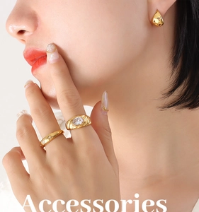 Détail d'une bague étoile dorée et de boucles d'oreilles goutte sur mannequin