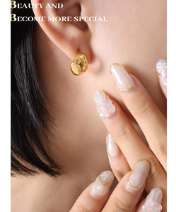 Gros plan sur les boucles d'oreilles étoiles évidées en métal doré brillant sur l'oreille