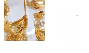 Vue macro des boucles d'oreilles étoile plaquées or avec logo de marque gravé