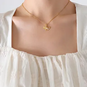 Elegant gold ginkgo leaf pendant necklace with diamond accent on model wearing white lace