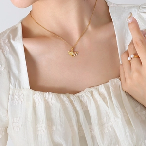 Elegant gold ginkgo leaf necklace and pearl ring set worn by model for a chic look