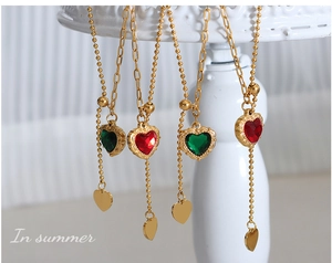 Close-up of heart zircon pendant necklaces with gold tassels and double-layer chains