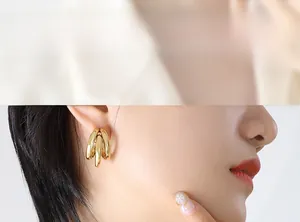 Close-up of triple-layered C-shaped hollow gold-plated earrings on model's ear