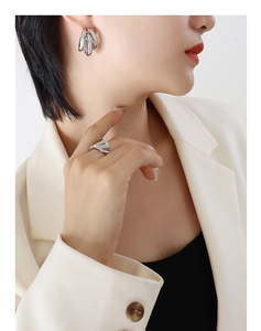 Close-up of a model wearing a triple-layered C-shaped hollow hoop earring in gold finish