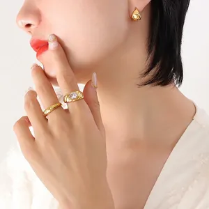 Élégantes boucles d'oreilles dorées et ensemble de bagues portés par un mannequin