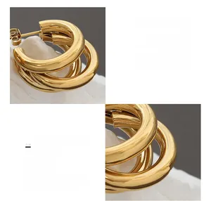 Close-up of triple-layered C-shaped 18K gold-plated titanium steel hoop earrings