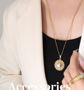 Macro view of French retro gold straw hat pendant with faux pearl and textured band ring