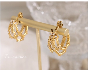 Détails de boucles d'oreilles en C torsadées dorées avec des cristaux de zircon