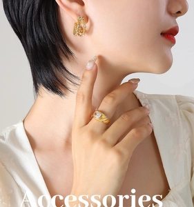 Détail de boucles d'oreilles créoles dorées multicouches avec incrustations de zircons