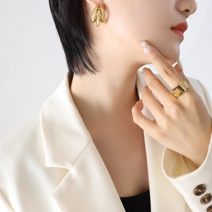 Vintage multi-layer gold C-shaped earrings and tiger eye stone ring set on female model