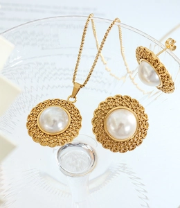 Detail of French vintage gold jewelry set with straw hat design and white pearls