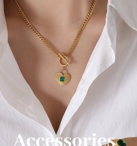 Close-up of gold chunky chain necklace with heart pendant and green malachite inlay