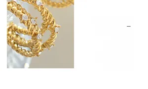 Détail de boucles d'oreilles en C torsadées dorées avec des zircons ronds étincelants