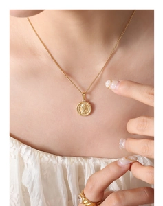 Gros plan du collier en or avec pendentif médaillon relief reine sur le cou
